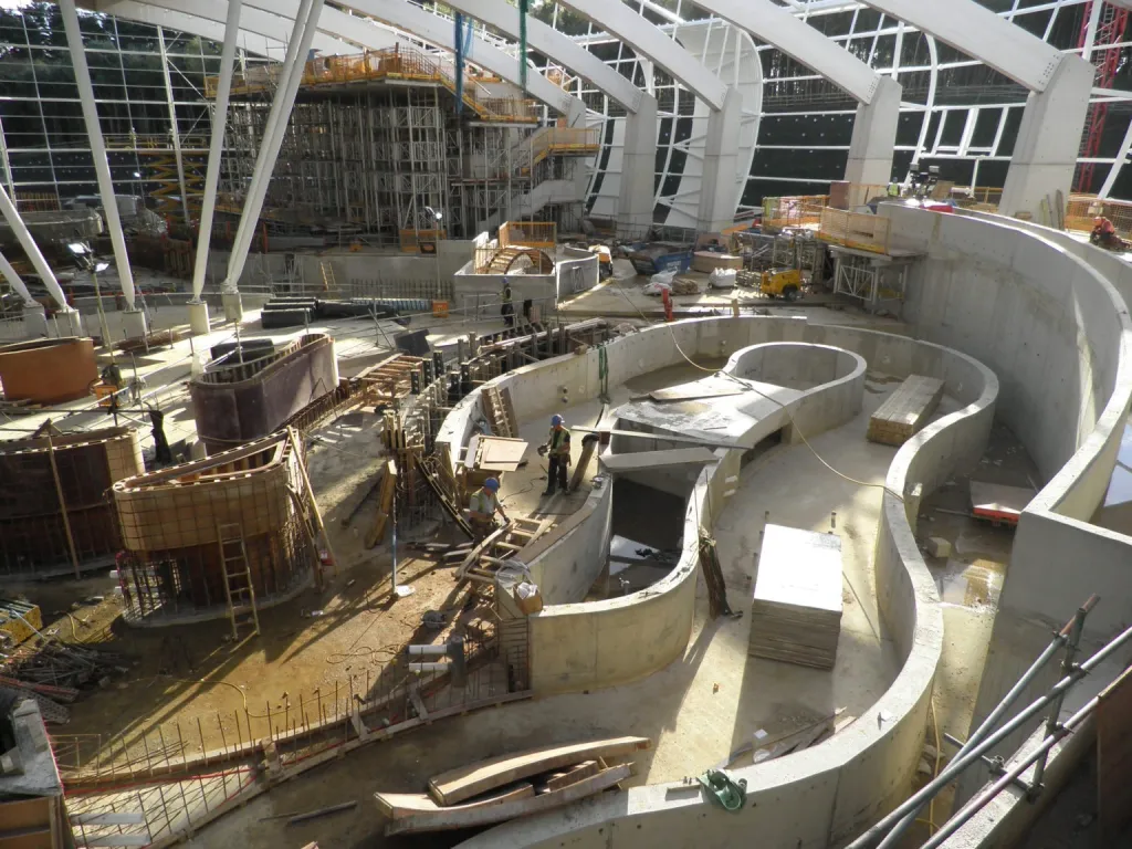 Two landmark reinforced concrete buildings across a 365-acre forest site, including a 70m single-span leisure pool structure with 12m buttress columns, and a three-storey hotel and entertainment complex housing 75 bedrooms, a spa, and a bowling alley.